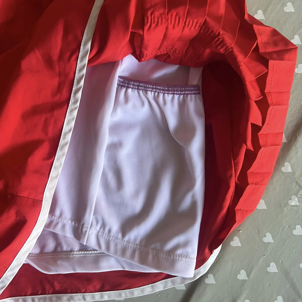 Um short de corrida vermelho virado do avesso, mostrando um short interno branco com um bolso costurado